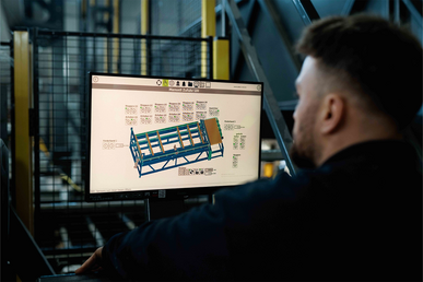 Mitarbeiter bedient das Terminal der Palettenfertigungsmaschine.