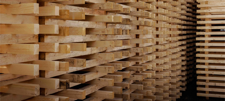 Seitenansicht eines hohen Stapels aus Holzpalettenleisten.