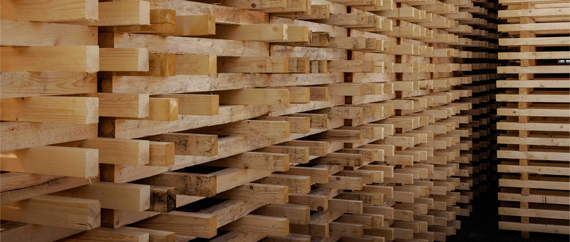 Seitenansicht eines hohen Stapels aus Holzpalettenleisten.