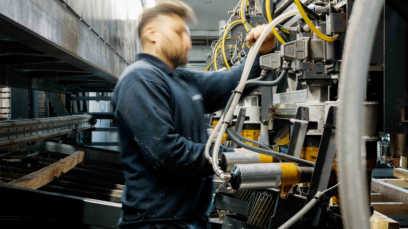 Mitarbeiter bedient die Palettenfertigungsmaschine.