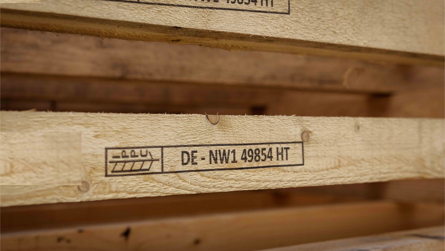 Mehrere Holzleisten mit IPPC/HT-Stempel im Stapel.