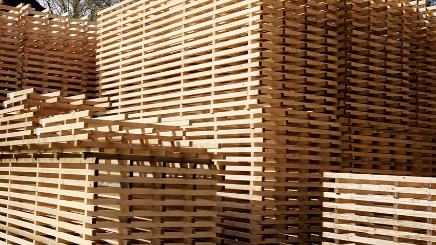 Große Stapel aus Holzpaletten im Außenbereich.