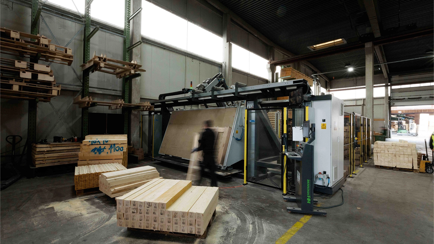 Palettenmaschine mit Schwenktisch, Holzteile und Sägespäne.