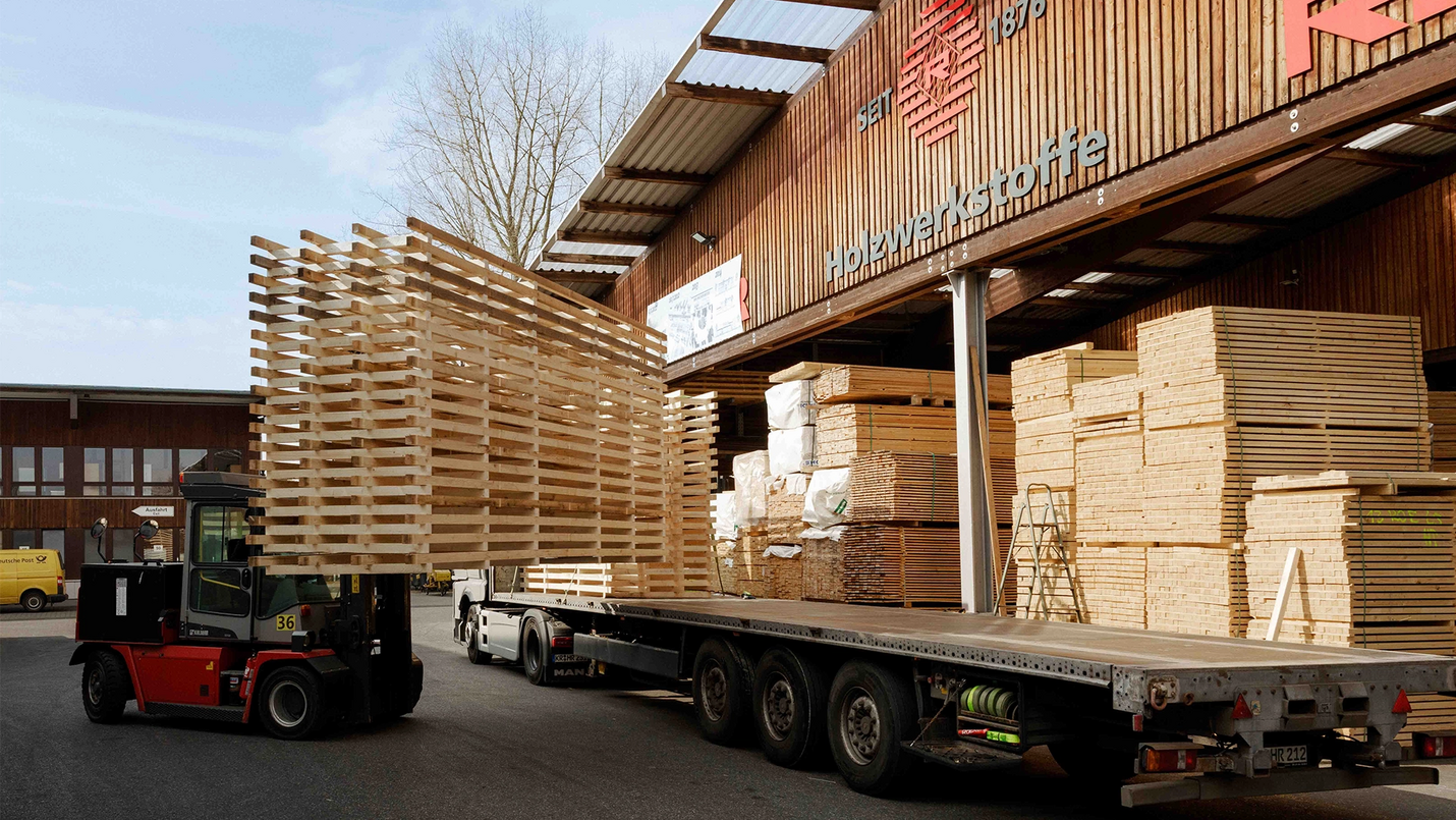 LKW wird mit gestapelten Holzpaletten beladen.
