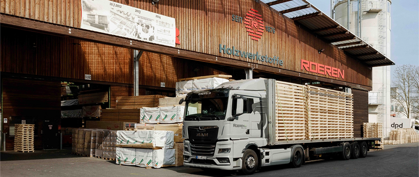 LKW wird an einem Holzlager mit Schnittholz beladen.