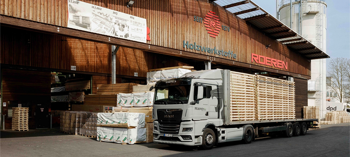 LKW wird an einem Holzlager mit Schnittholz beladen.
