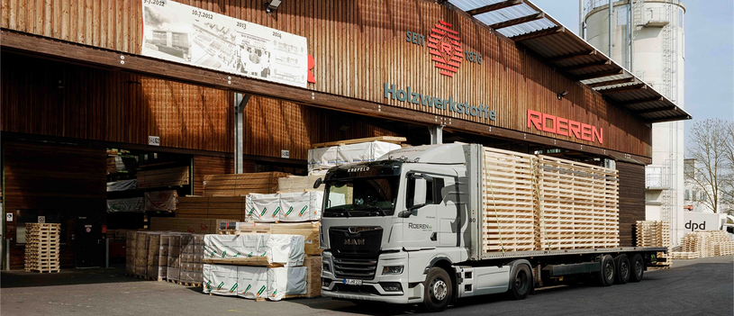 LKW wird an einem Holzlager mit Schnittholz beladen.
