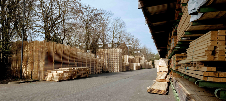 View of an access road between warehouse buildings with roller doors.