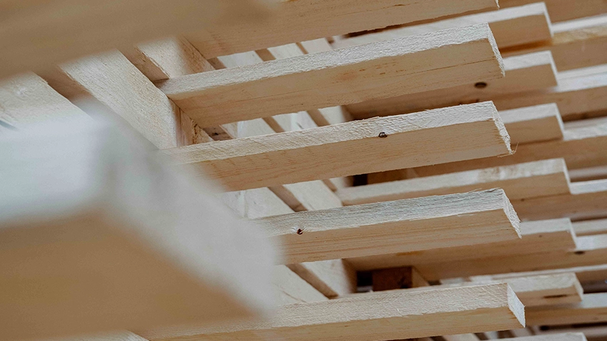 Detailansicht gestapelter Holzleisten einer Palette.