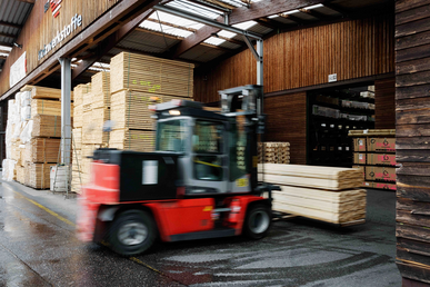Gabelstapler transportiert Holzware im Roeren Holzlager.